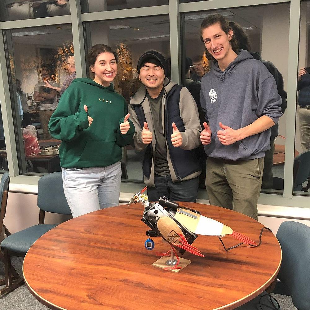 Three students from winning team show off their bird sculpture.